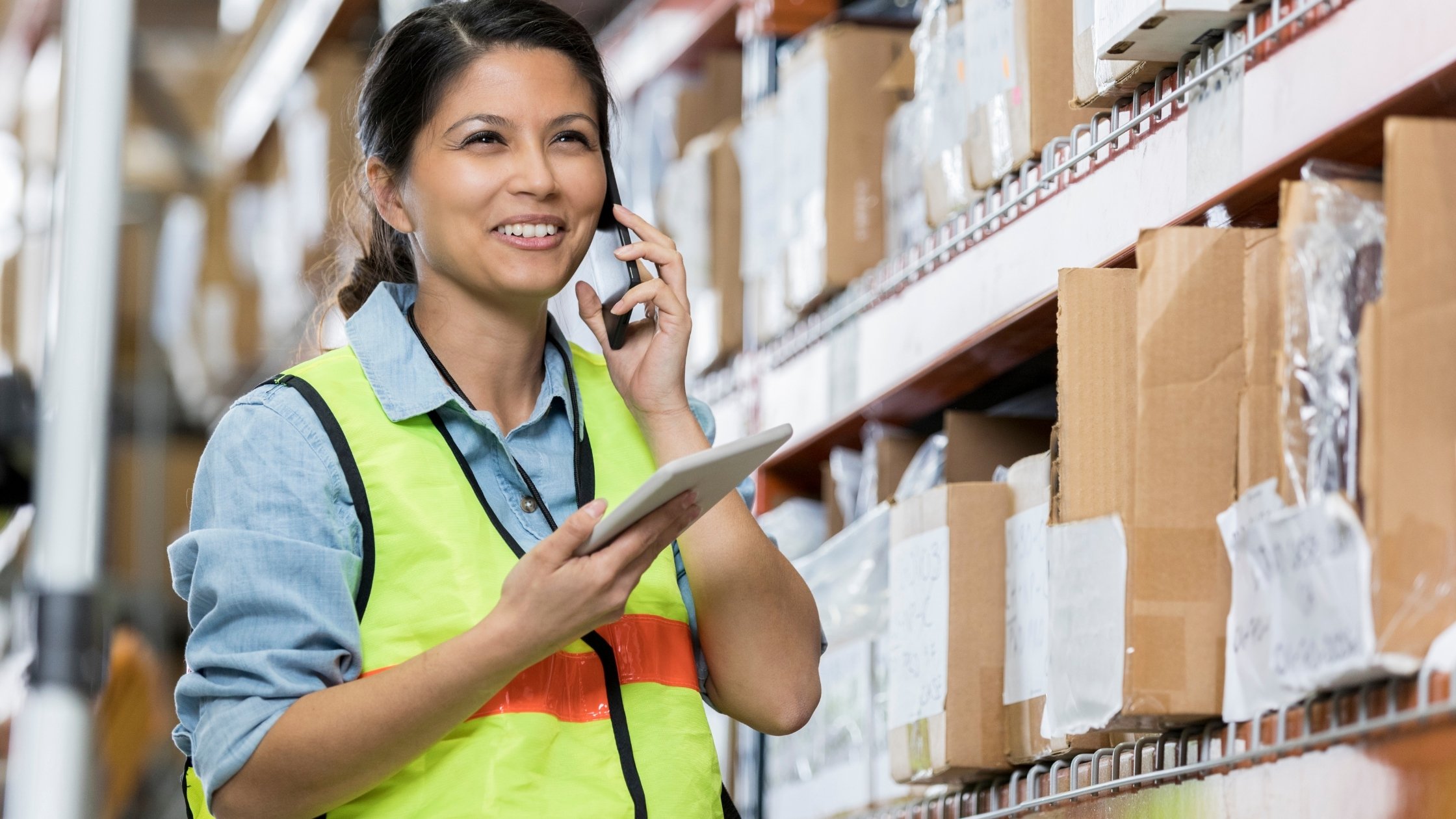  A person in a warehouse using their own tablet and phoen to complete inventory 