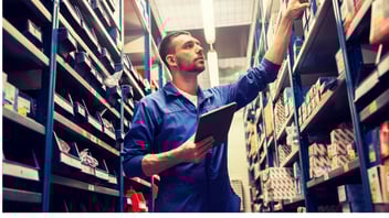 A person with a tablet looking at stock in a warehouse